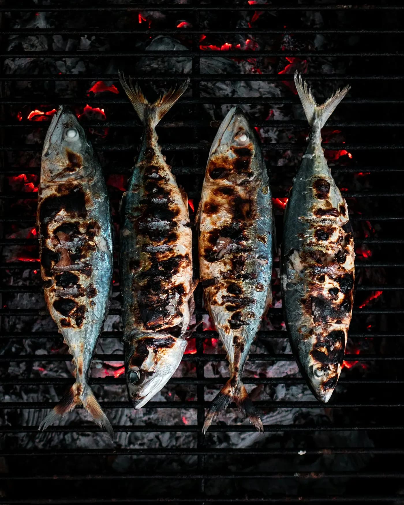 Poissons braisés sur la grille, peau dorée et marquée par le feu